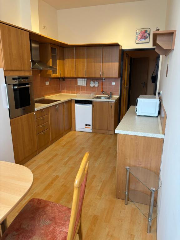 a large kitchen with wooden cabinets and a table at Apartmán Esser 3 in Milovice