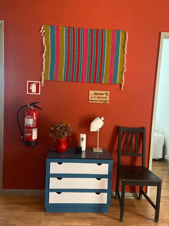 a room with a dresser and a chair and a blanket at Eskama hostel in Esposende