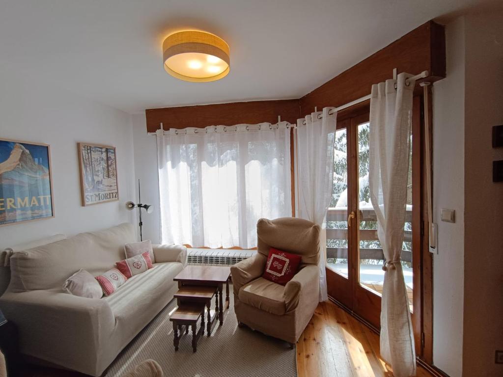 塞爾勒的住宿－El Sarrau-Cerler，客厅配有沙发和椅子