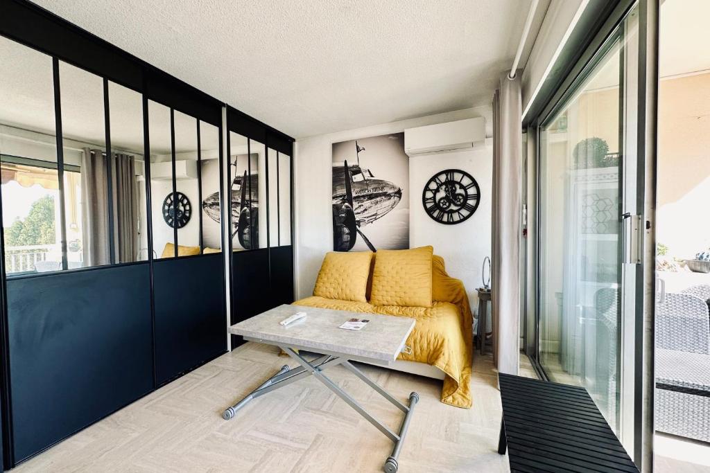 um quarto com uma cama e uma mesa em Cosy family nest with balcony and shared pool em Mandelieu-la-Napoule