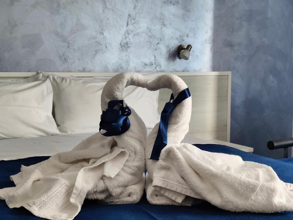 un cisne envuelto en una manta en una cama en B&B Casa Alessio en Santa Domenica
