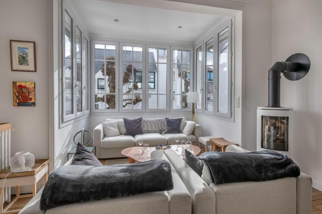 a living room with two couches and a table at Parenthèse en famille et détente au Pouliguen in Le Pouliguen