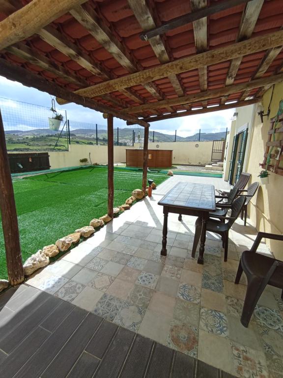 un patio con mesa y sillas en una terraza en Sossego e tranquilidade - Valley Guest House - Perto de Lisboa en Arruda dos Vinhos