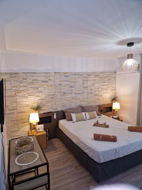 a bedroom with a large bed and a stone wall at The Ohana Studio in Saint-François