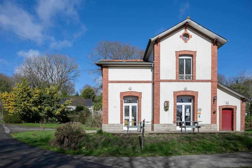 une vieille maison en briques avec une porte rouge dans l'établissement Gîte Ty Bris, à Keriven