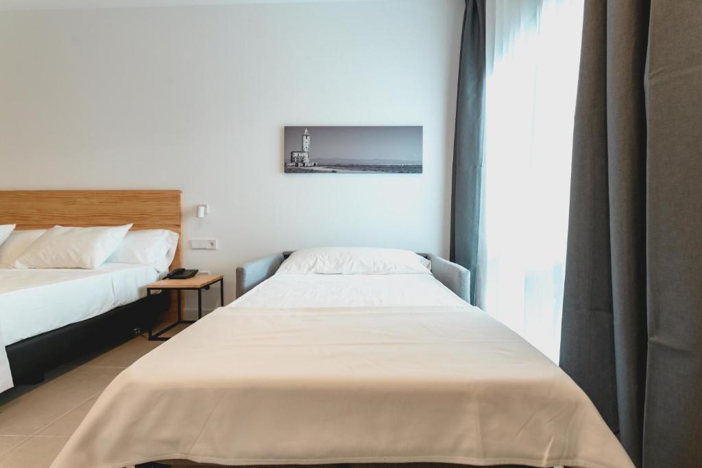 a bedroom with two beds and a window at HOTEL ALOVE in San José