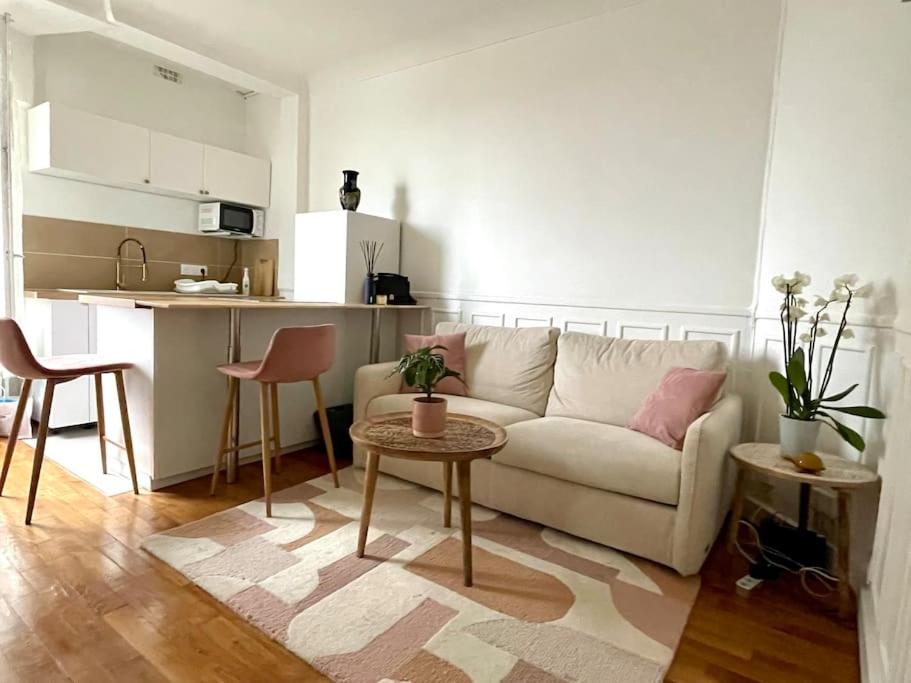 een woonkamer met een bank en een tafel en een keuken bij Appartement 4 personnes JO Paris 2024 in Vincennes