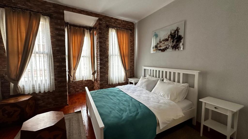 a bedroom with a bed in a room with windows at Lia Suit Beşiktaş in Istanbul