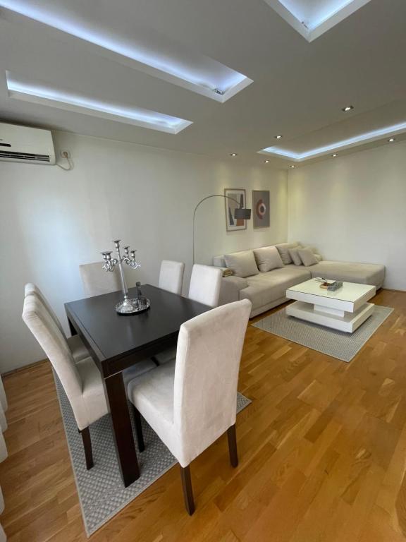 a living room with a table and chairs and a couch at Charme apartman in Kruševac
