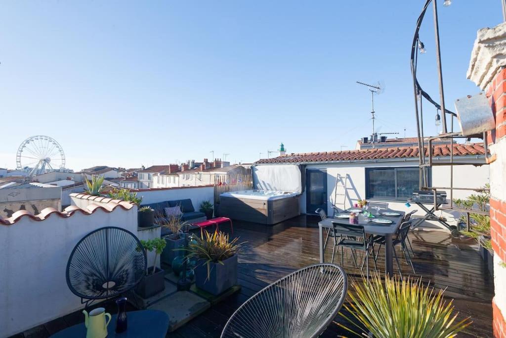 d'un balcon sur le toit avec une table et des chaises. dans l'établissement L'Olympe - triplex avec spa et rooftop Classé 4*, à La Rochelle
