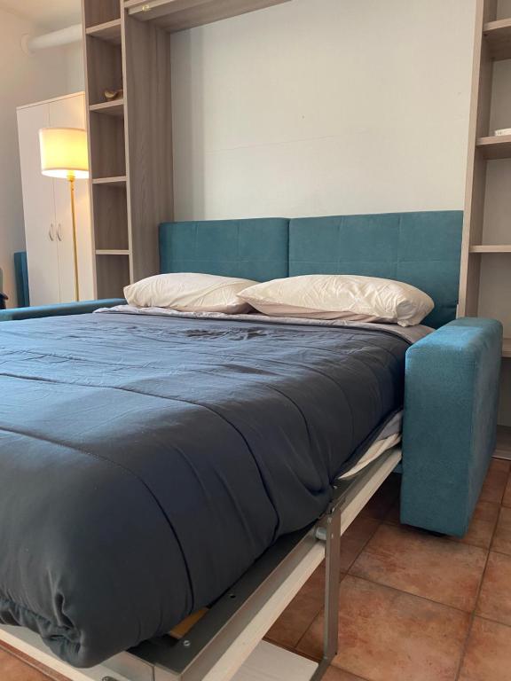 un letto in una camera con telaio blu di Appartamento ONE a Novara