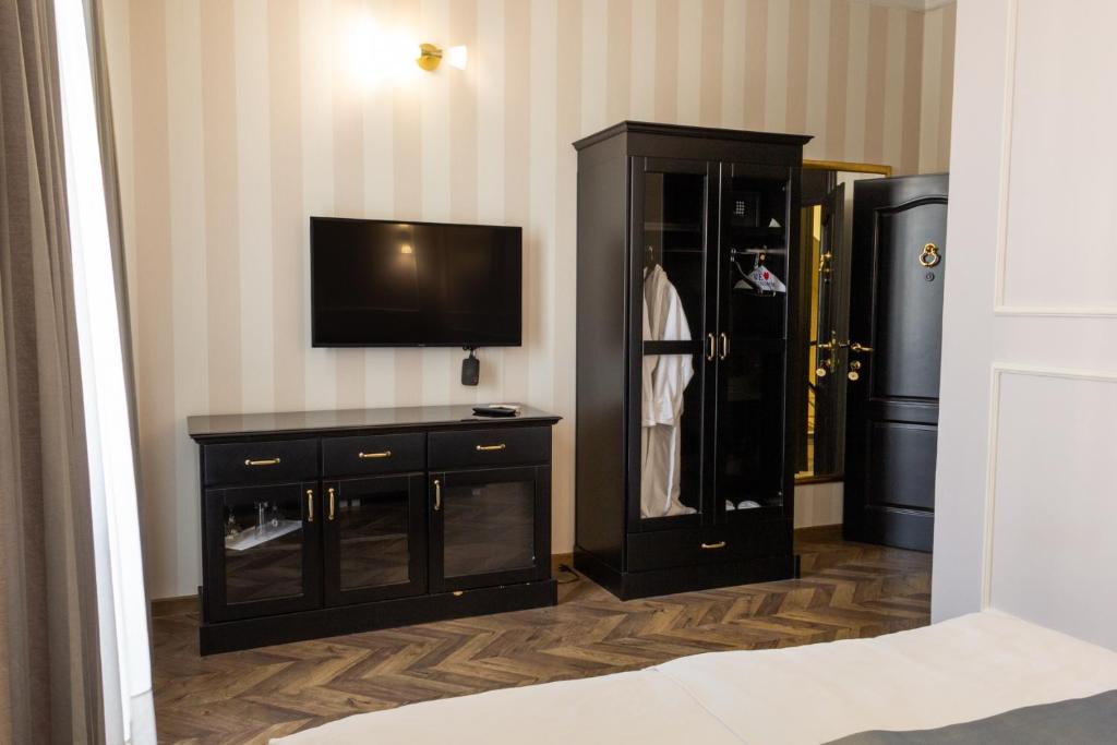 a room with a tv and a black cabinet at Hotel Balkan Centar in Bijeljina