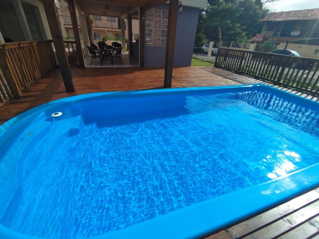 uma grande piscina azul com água azul em Pousada Bombinhas House em Bombinhas