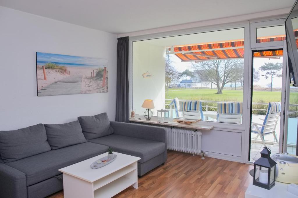 ein Wohnzimmer mit einem Sofa und einem Tisch in der Unterkunft Fürstenhof Whg 108 inkl WLAN in Grömitz