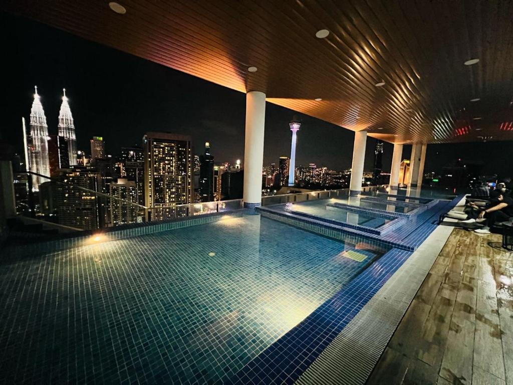 una piscina en la parte superior de un edificio con vistas al perfil urbano en City suites colony by infinitum Klcc, en Kuala Lumpur