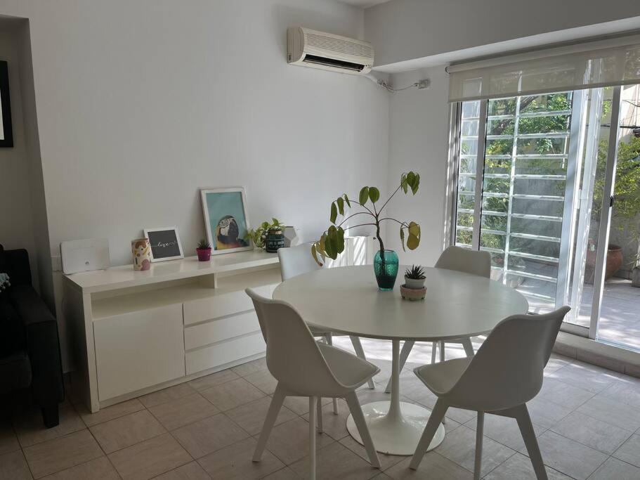uma cozinha com uma mesa branca e cadeiras e uma mesa em Único 2 ambientes, terraza y parrilla en Núñez em Buenos Aires