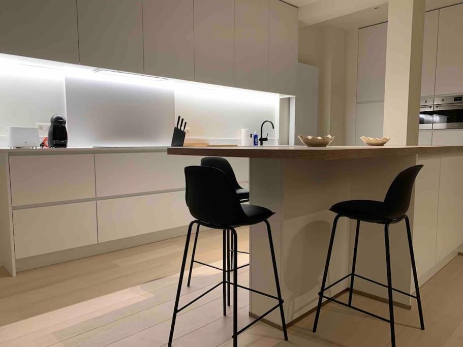 een keuken met 2 barkrukken en een aanrecht bij Luxury 2 Bedroom - Antwerp City Centre in Antwerpen
