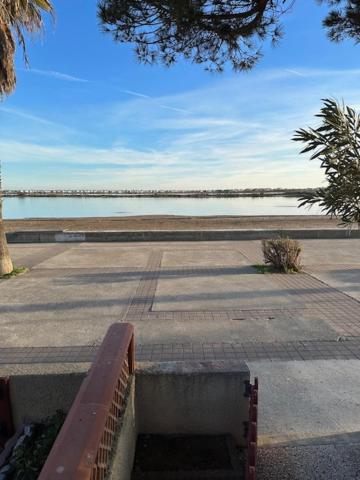 een bank voor een waterlichaam bij VILLA DU PIN in Gruissan