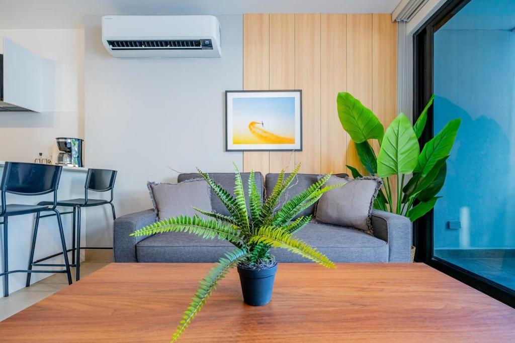 uma sala de estar com um sofá e uma mesa com uma planta em San Francisco by Wynwood House em Cidade do Panamá