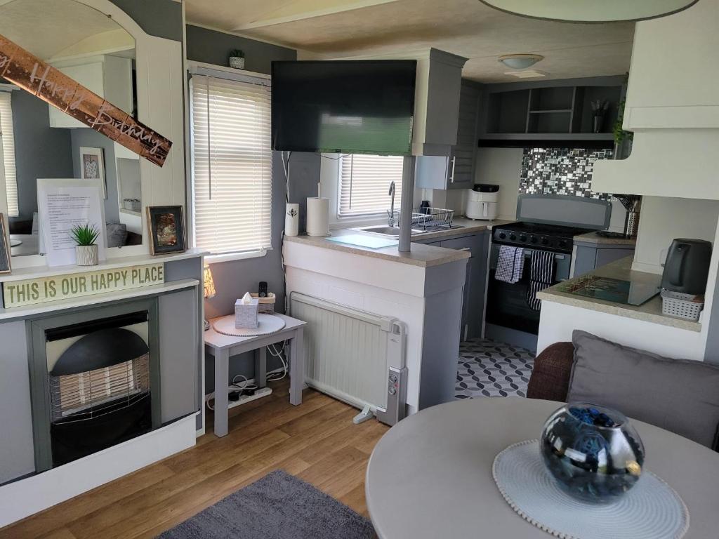 eine Küche und ein Wohnzimmer mit einer Theke und einem Tisch in der Unterkunft Thorness Bay in Porchfield