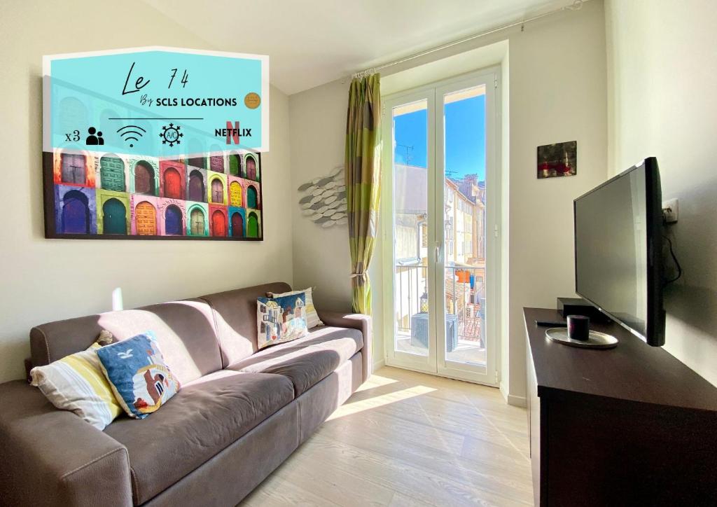 un salon avec un canapé et une télévision à écran plat dans l'établissement Le 74 By SCLS Locations, à Cannes