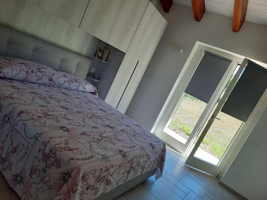 sypialnia z łóżkiem i otwartym oknem w obiekcie VILLA MILLEFIORI w mieście Tornareccio