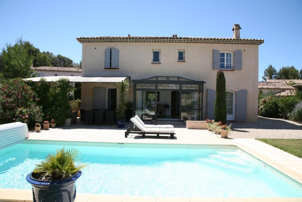 a villa with a swimming pool in front of a house at Golf de Pont Royal Villa les Micocouliers climatisée 4 chambres Piscine chauffée Parking in Mallemort