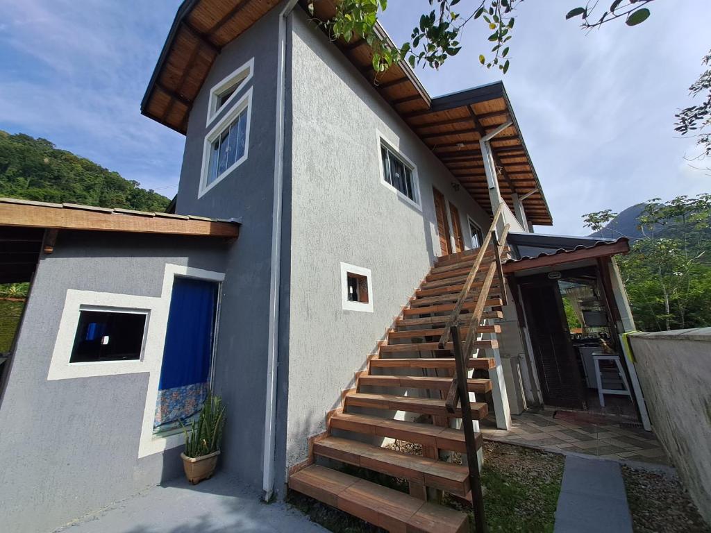 a house with a blue door and wooden stairs at Chale Sol in Caraguatatuba