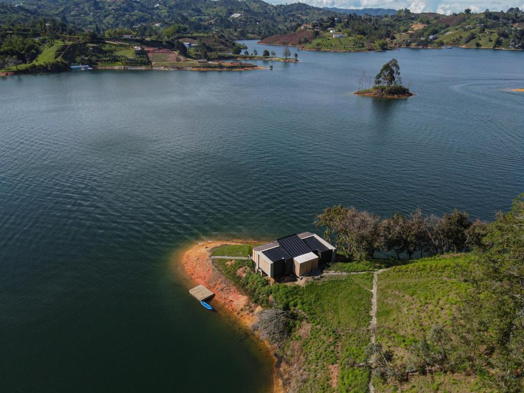 an island with a house in the middle of a lake at La Pausa Hotelbistro in Guatapé