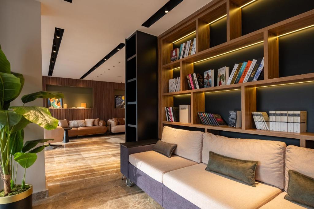 a living room with a couch and bookshelves at FLY POINT AIRPORT HOTEL in Arnavutköy