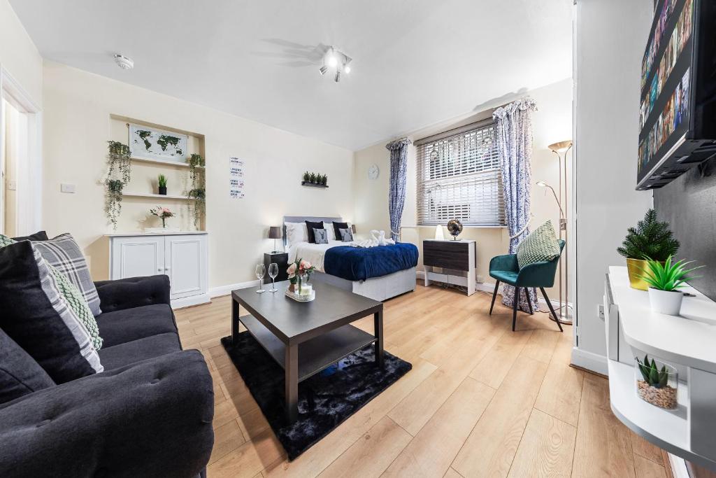 a living room with a couch and a table at Heart of London Luxury, 1 Min Walk from Paddington Station, Beautiful Apartment with Smart TV in London