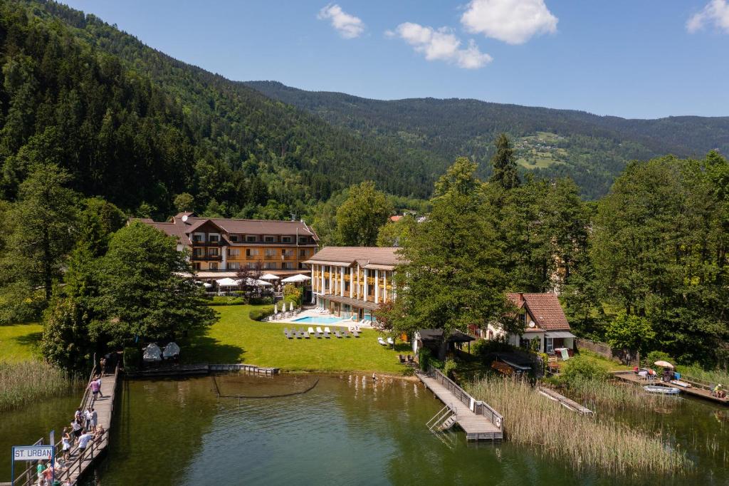 an aerial view of a resort with a lake and mountains at Seehotel Urban in Bodensdorf