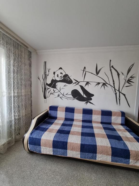 a bedroom with a bed with a panda on the wall at Panda flat in Astana