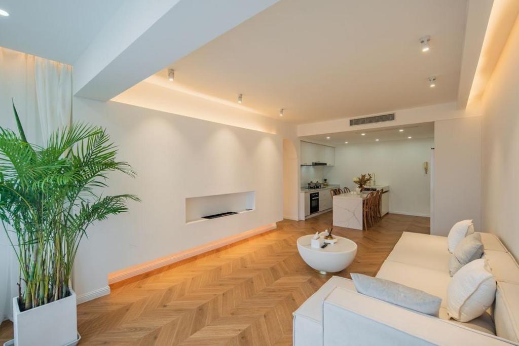 a living room with a white couch and a plant at Shanghai Hills & Serendipity Homestay in Shanghai