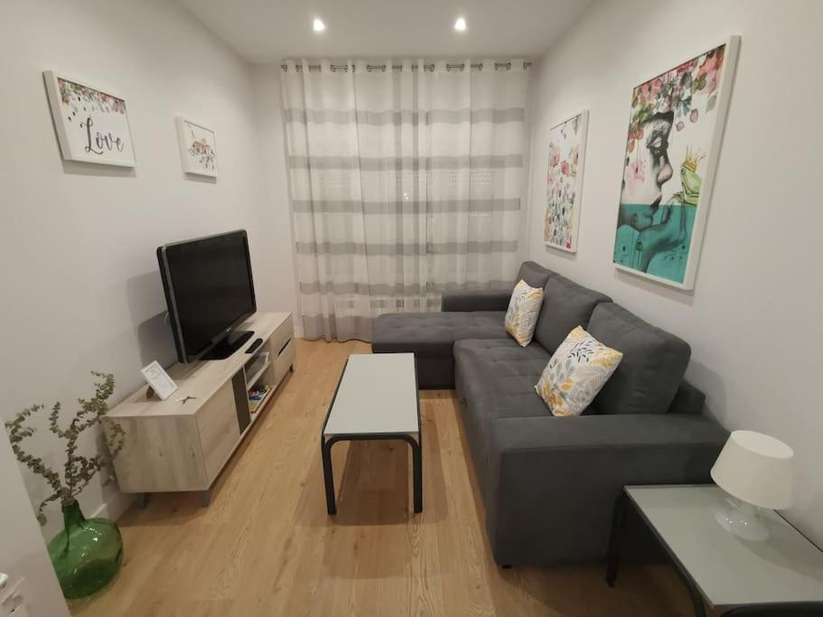 a living room with a couch and a tv at Casa Elisa 1 in León