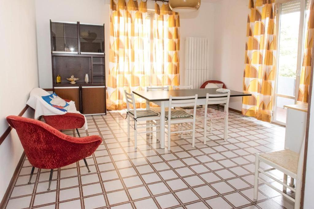 sala de estar con mesa y sillas y cocina en P002 - Porto Recanati, trilocale a due passi dal mare en Porto Recanati