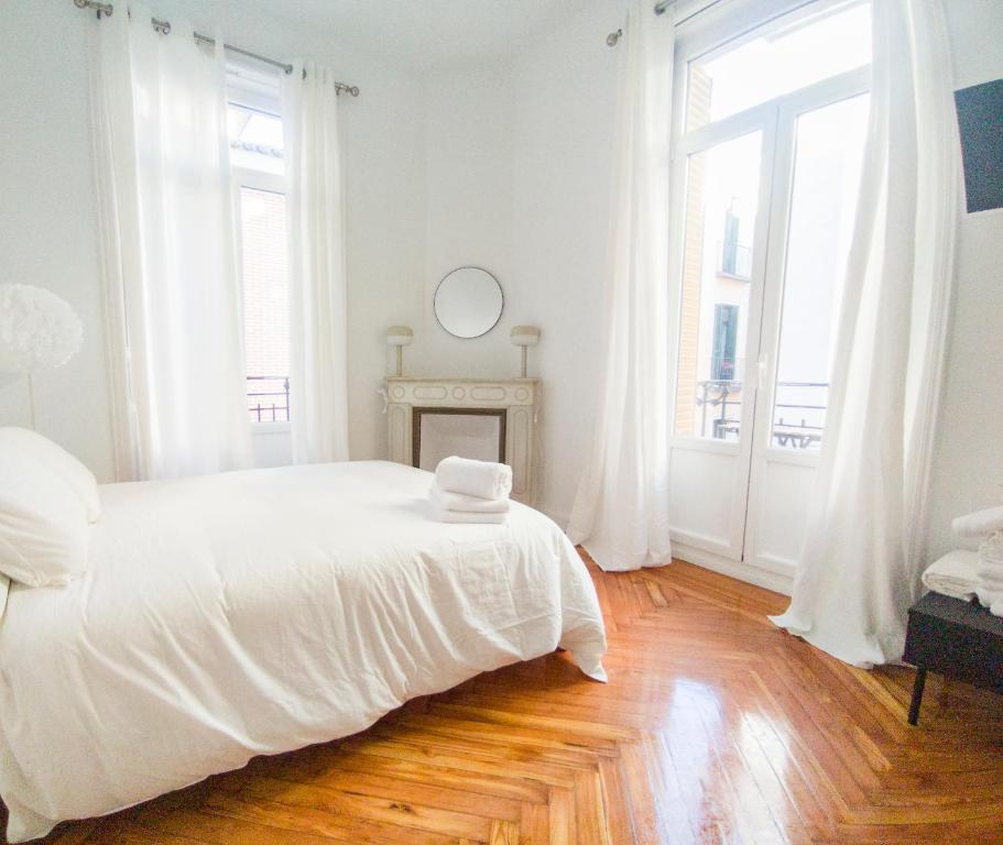 a white bedroom with a large bed and windows at MEZZANINE ORANGE in Madrid