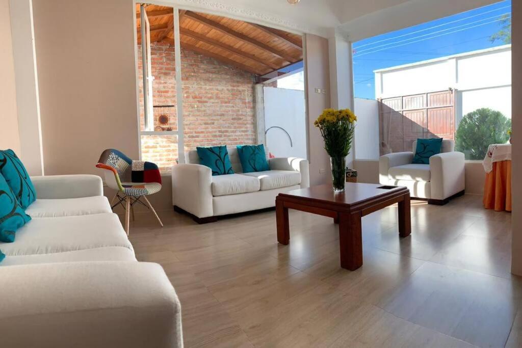 uma sala de estar com dois sofás brancos e uma mesa em Casa Pepita em Vilcabamba