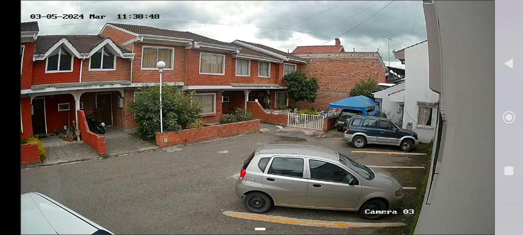 une voiture garée dans un parking en face des maisons dans l'établissement Habitaciones en vivienda ubicada en urbanización privada, à Cuenca