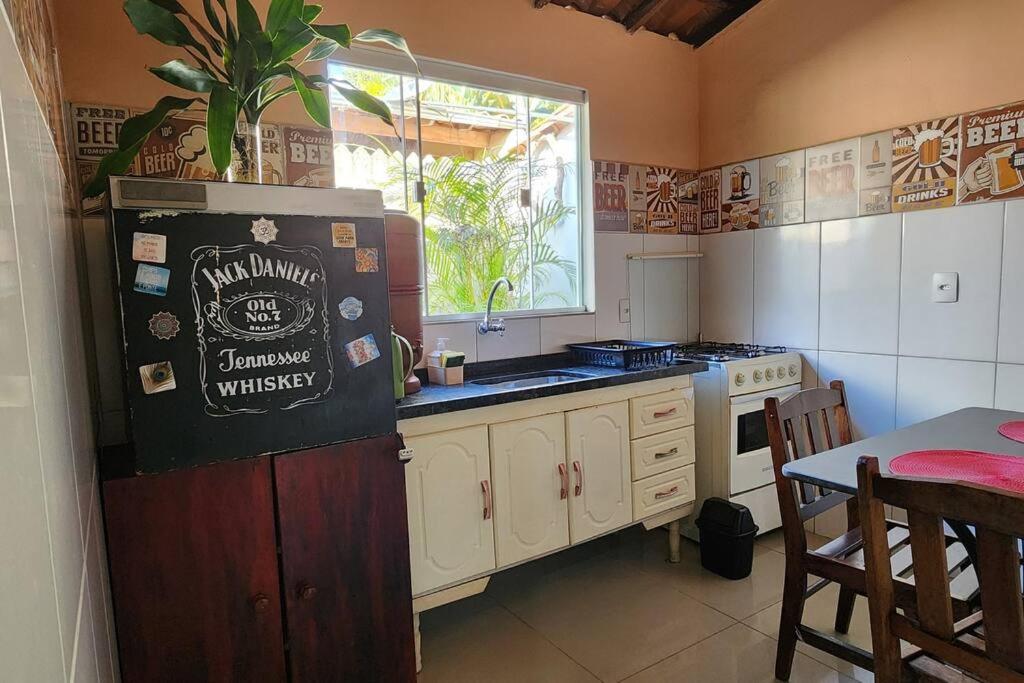a kitchen with a refrigerator and a table and a window at Casa Dhamma in São João del Rei