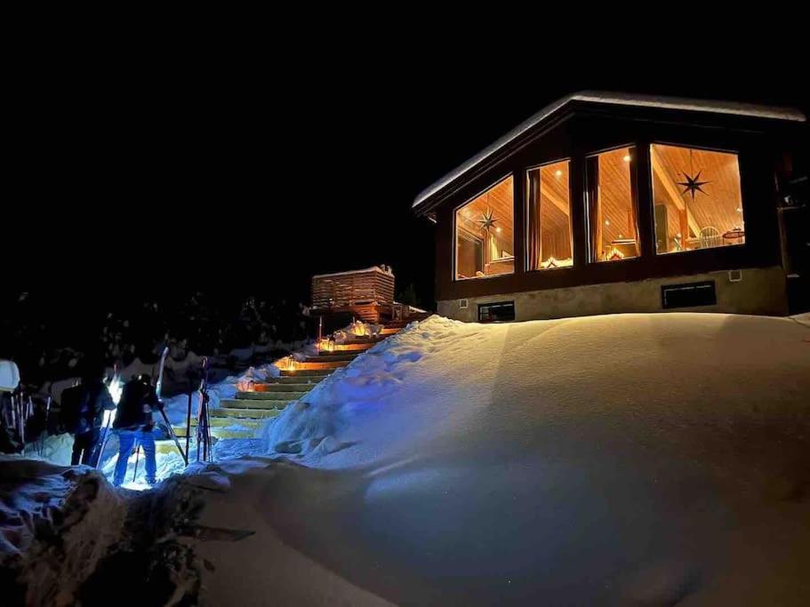 um edifício com luzes acesas na neve à noite em Beitostølen-Sørliestølen -Nyrenovert hytte 2022 på Slettefjell em Vevle