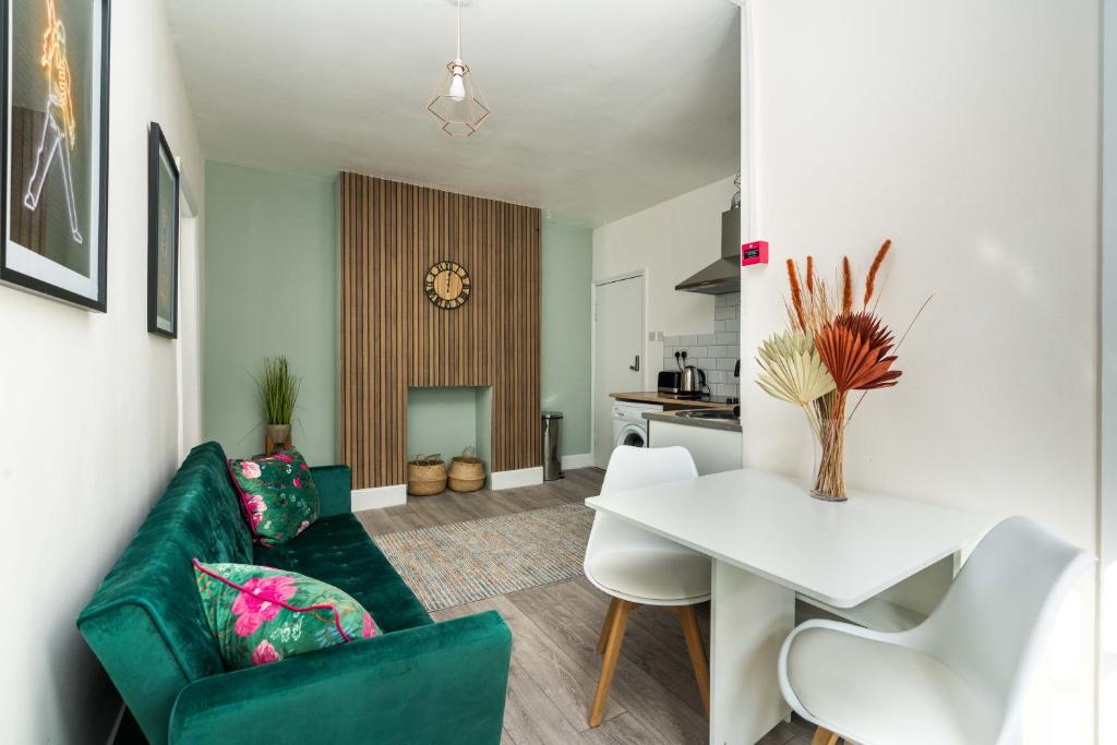 uma sala de estar com um sofá verde e uma mesa branca em Shoreditch-bricklane-convenient-central-liverpoolstreet em Londres