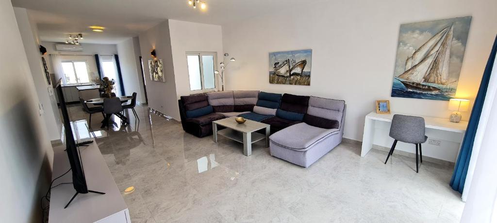 ein Wohnzimmer mit einem Sofa und einem Tisch in der Unterkunft Seaside Serenity - Luxe Penthouse - near the beach in Mellieħa