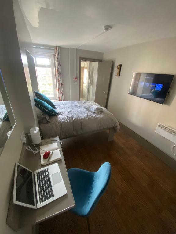 1 dormitorio con 1 cama y escritorio con ordenador portátil en Quiet cosy 1 bedroom apartment Carrington F1 en Nottingham