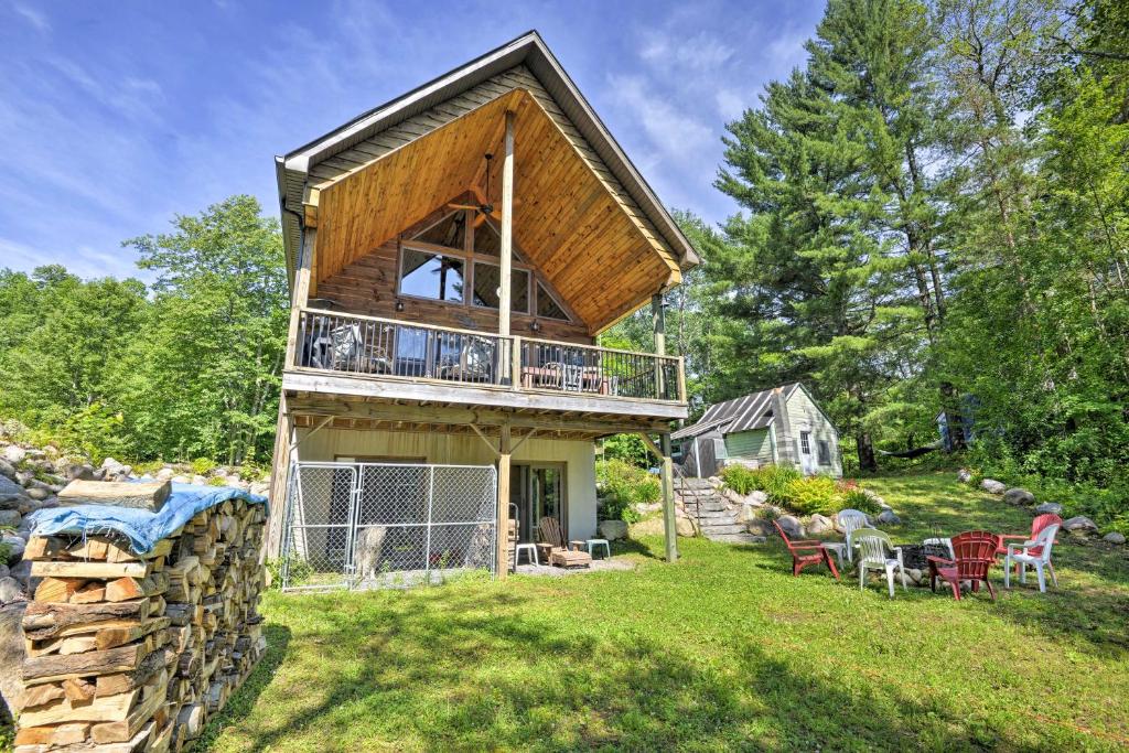 une maison entourée d'une terrasse couverte. dans l'établissement Quiet Adirondack Cabin on Private Lake!, à Glenfield