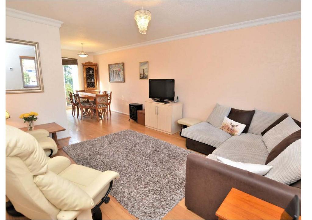 een woonkamer met een bank en een tv bij Cosy & Peaceful 3B Home in Sandridge, St Albans in Saint Albans