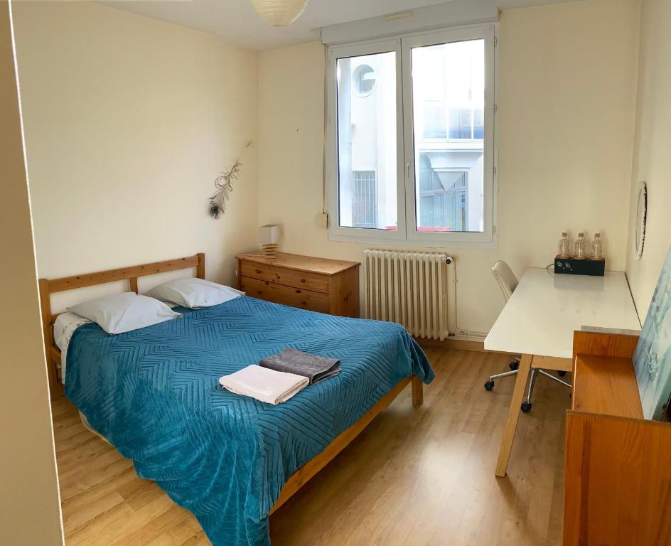 a bedroom with a bed and a desk and a window at Chambre Angers gare-centre ville 2 in Angers