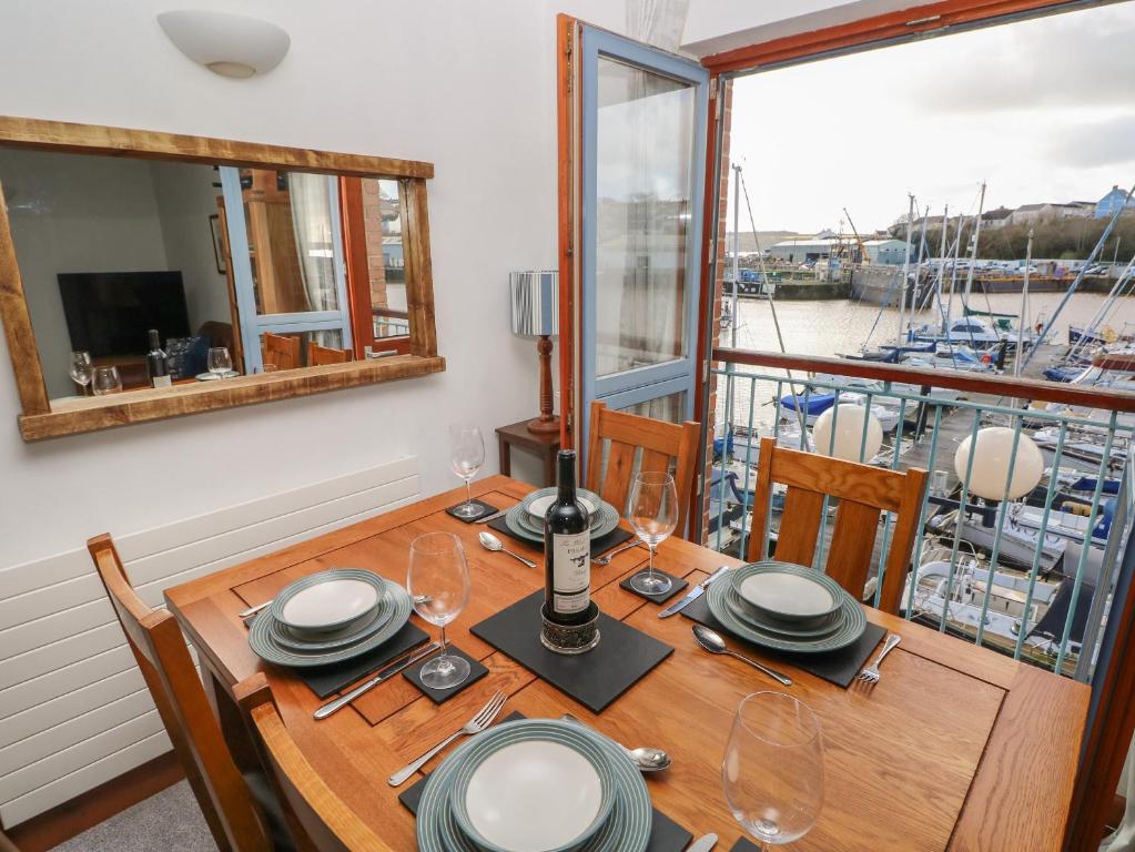 a dining room table with a view of a boat at The Sail Loft in Milford Haven