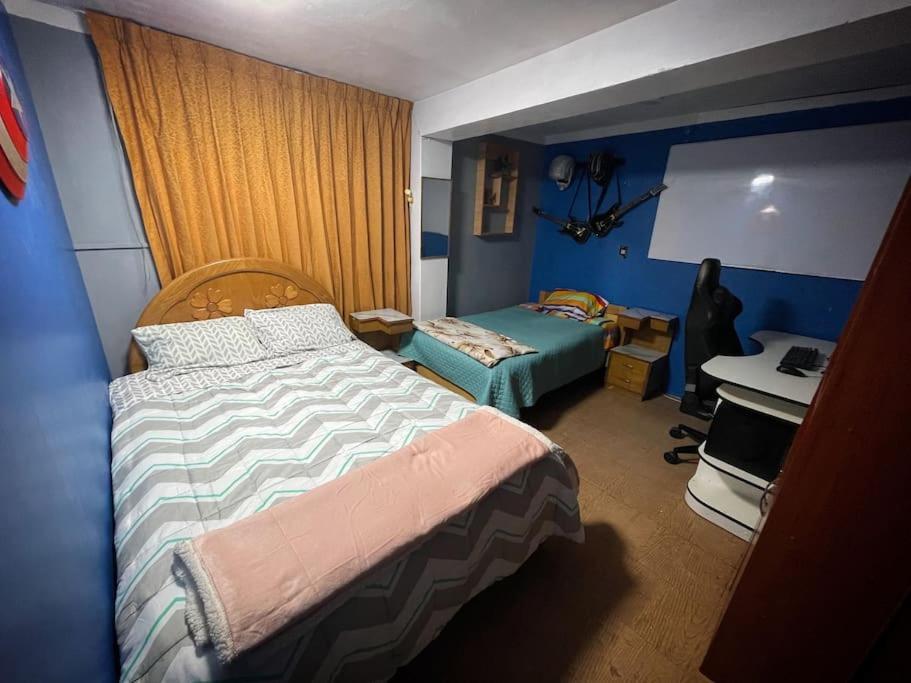 a bedroom with two beds and a desk in it at Departamento Céntrico cómodo y acogedor in Puno