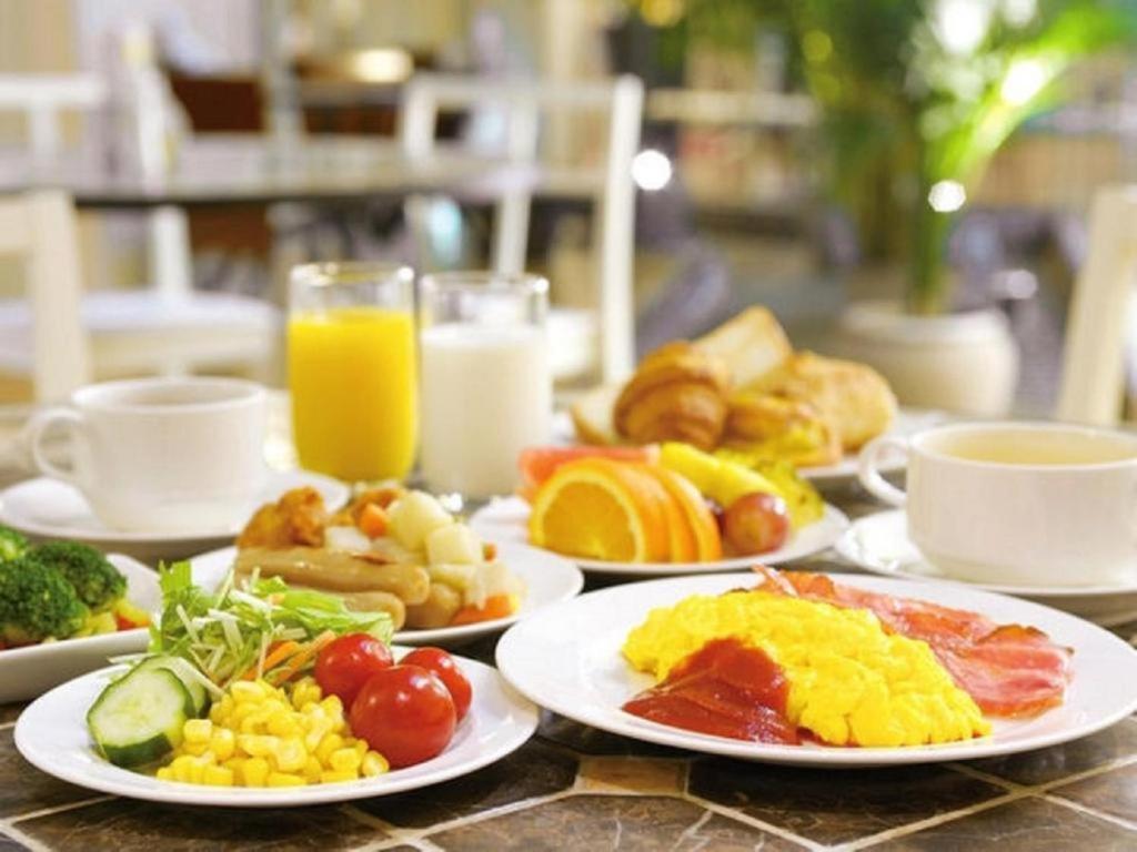 una mesa cubierta con platos de desayuno y zumo de naranja en Old City Inn Hotel en Bakú